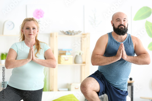 Overweight couple doing exe...
