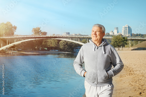 Mature man walking near river