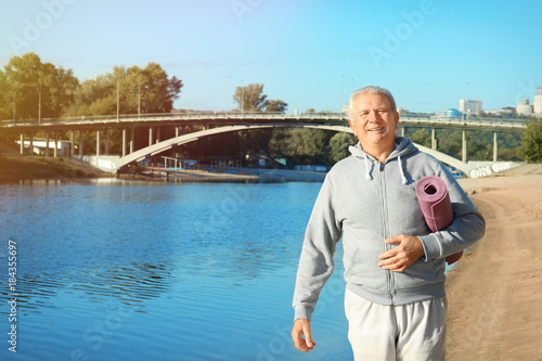 Mature man with mat walking...
