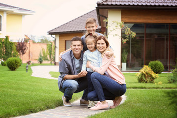 Happy family in courtyard near their house