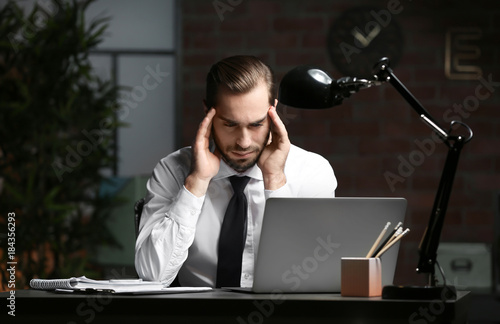Tired young man using lapto...