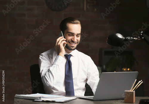 Young man with laptop and c...