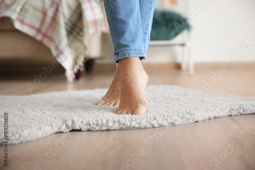 Woman standing on soft white carpet at home