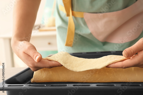 Woman putting puff pastry on baking tray