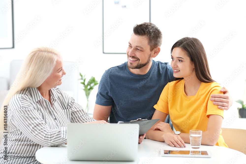 Female insurance agent consulting young couple in office Female insurance agent consulting young couple in office