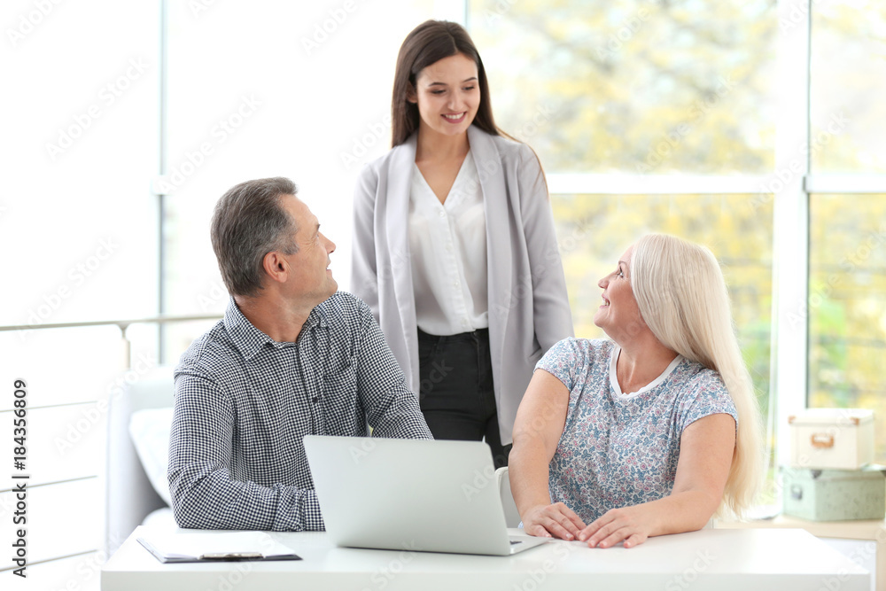 Female insurance agent consulting senior couple in office Female insurance agent consulting senior couple in office