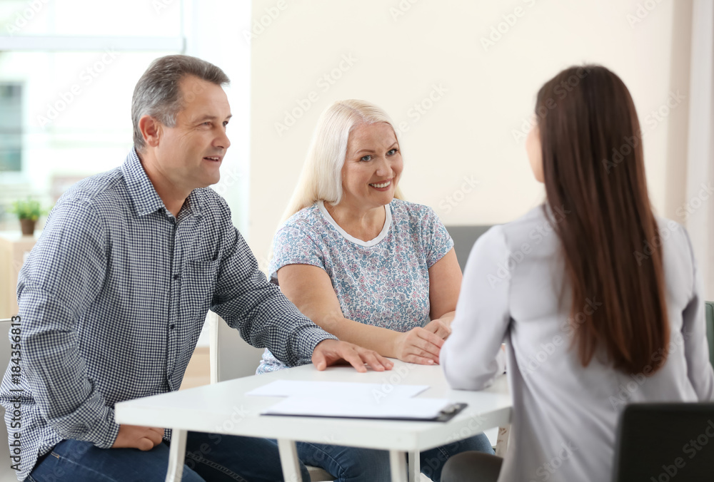 Obraz premium Female insurance agent consulting senior couple in office