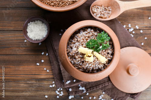 Pot with cooked buckwheat on table