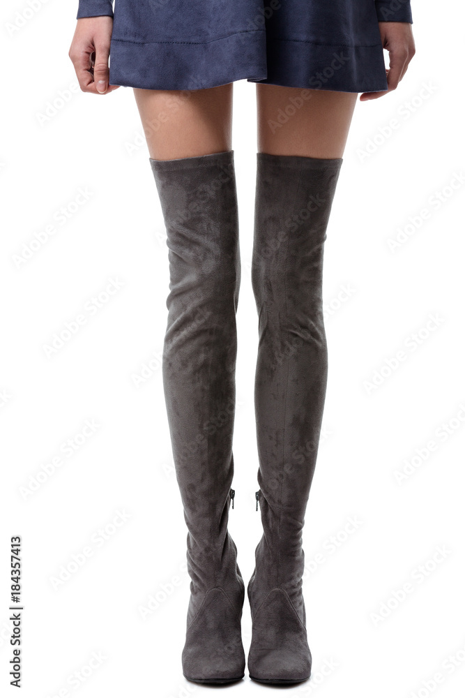 Close up photo of long woman legs in gray boots with heels on white background Close up photo of long woman legs in gray boots with heels on white background