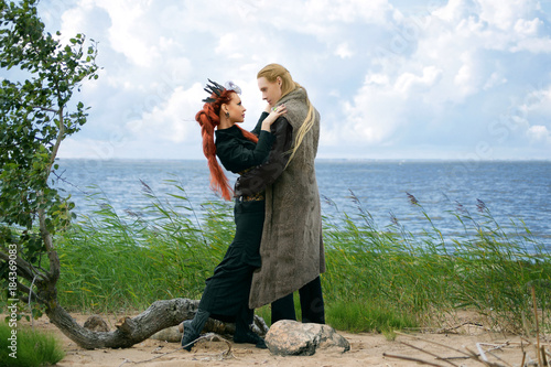 strangely dressed man and woman dancing on the sea