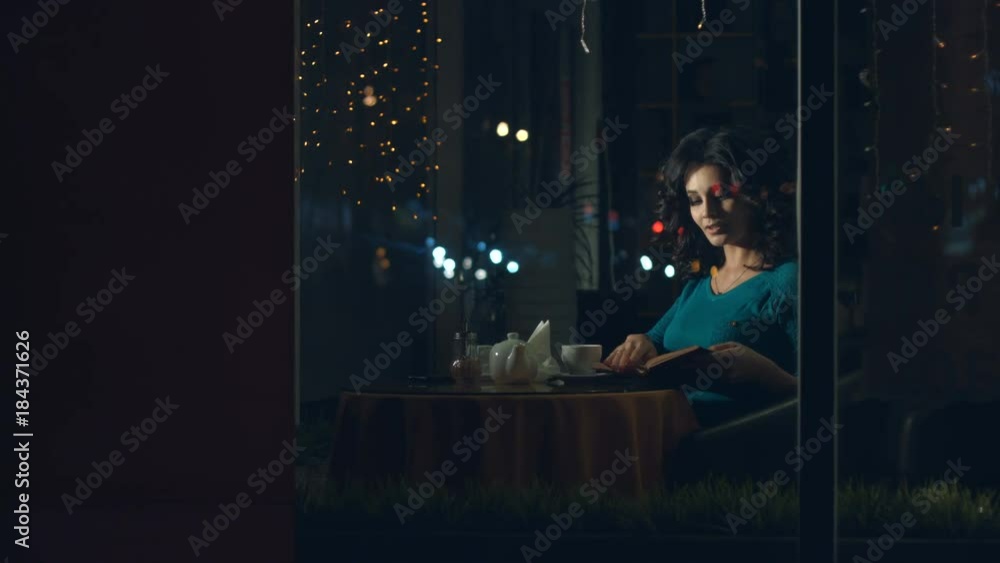 Cute womanin in a cafe.
A pretty woman is sitting in a cafe behind the glass and reading a book.
The glass reflects the traffic of urban transport. Cute womanin in a cafe.
A pretty woman is sitting in a cafe behind the glass and reading a book.
The glass reflects the traffic of urban transport.