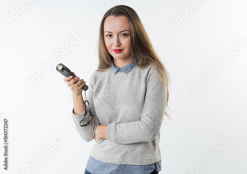 Woman holding an electrical torch flashlight isolated on a white background. Search concept idea