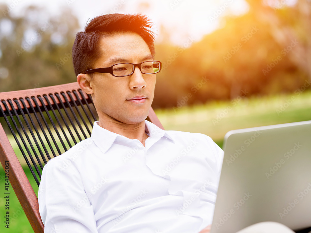 Fototapeta premium Young businessman relaxing during her break in park
