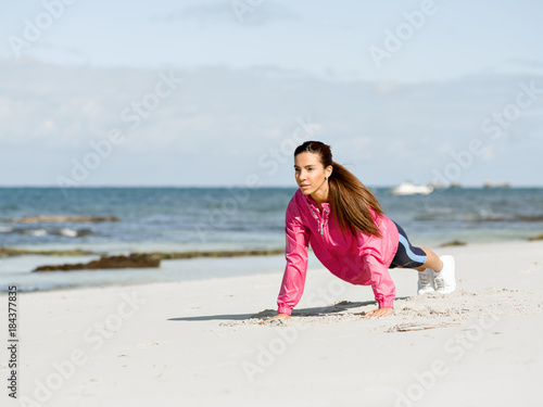 Young woman at the beach doing exercises