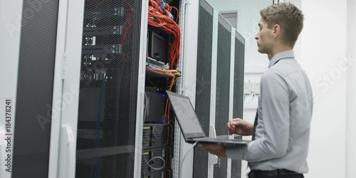 male technitian using computer in data center photo