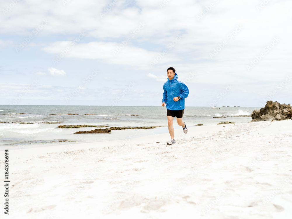 Young man running along seaside