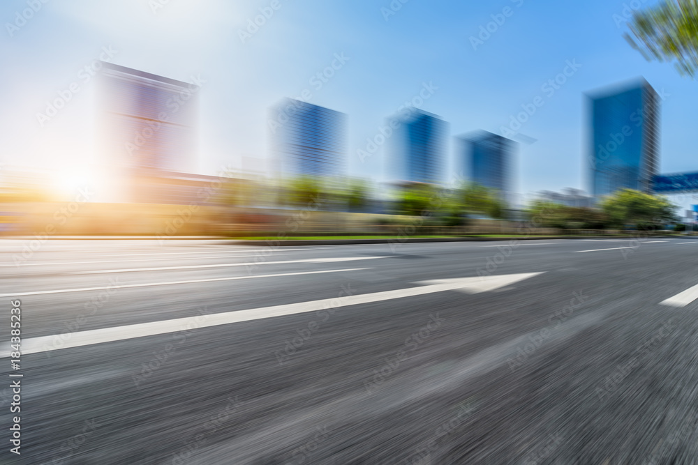blurry asphalt road front of modern buildings
