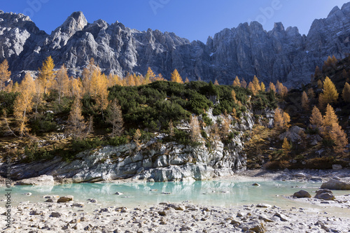 Lake Sorapiss with its rocks sourrounding in autumn, Dolomites, Province of Belluno, Veneto, Italy photo