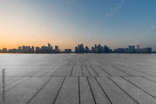 empty brick floor with cityscape and skyline at twilight.