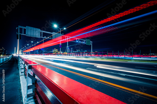 light trails go though the bridge in the downtown district, china. © hallojulie