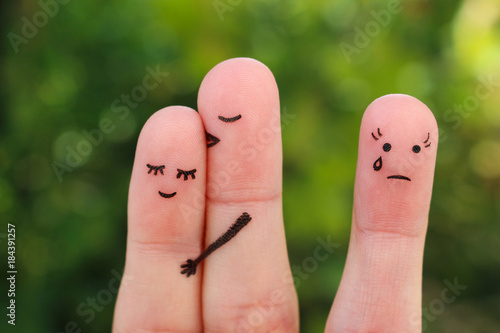 Fingers art of happy couple. Man kisses woman on cheek. Girl is jealous and angry.