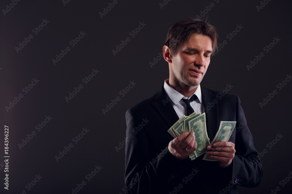 Image of man in suit counting dollars isolated on black background. Image of man in suit counting dollars isolated on black background.