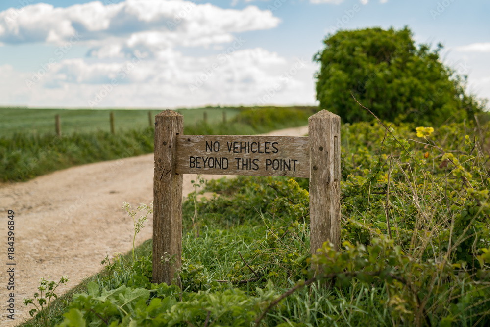 Sign: No vehicles beyond this point, with a blurry background, seen near Worth Matravers, Jurassic Coast, Dorset, UK Sign: No vehicles beyond this point, with a blurry background, seen near Worth Matravers, Jurassic Coast, Dorset, UK