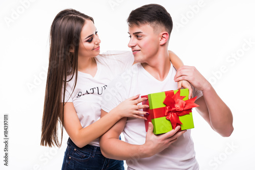 Pretty brunette surprising boyfriend with a gift on white background