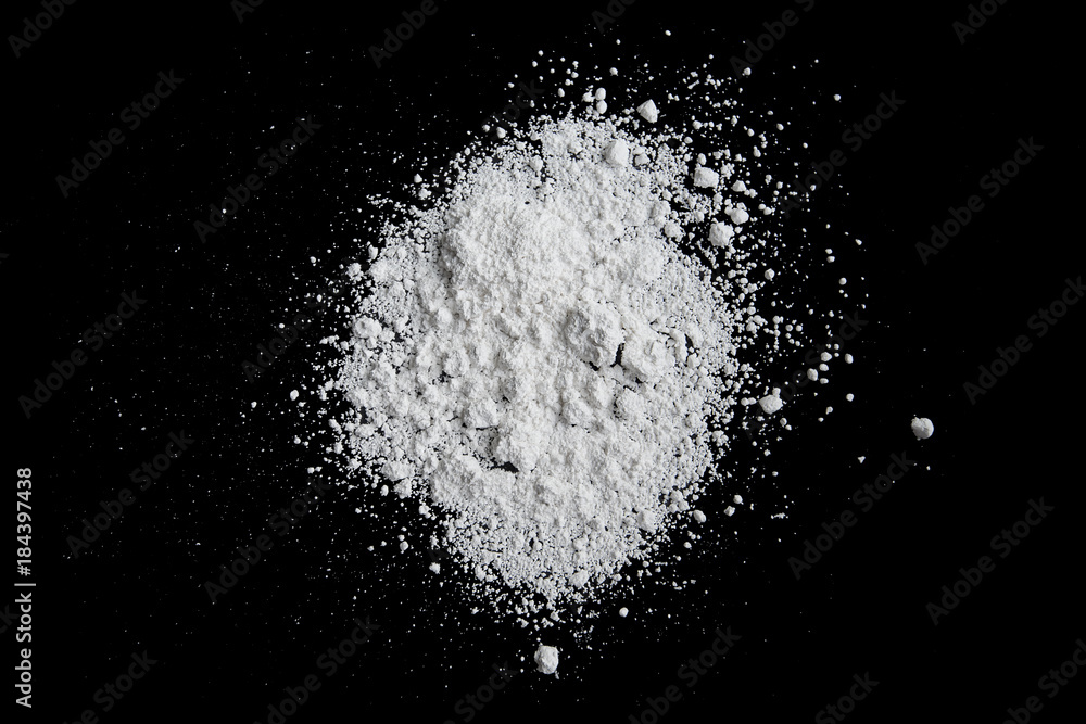 White powder isolated on black background, dust or powder texture