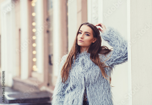 Happy winter time in big city of charming girl posing on street in fur coat.