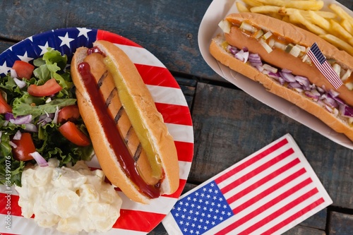 Hot dog and American flag on wooden table