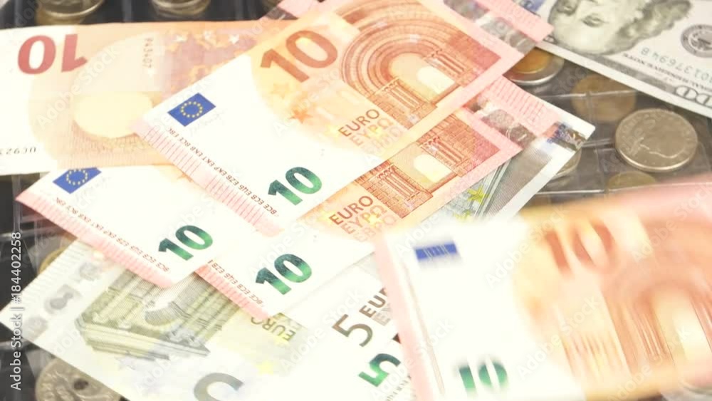 Euro and dollar bills of various denominations in the background of a collection of coins Euro and dollar bills of various denominations in the background of a collection of coins