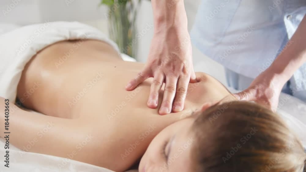 Massage for back of young woman. Man rmassaging for young blonde female Massage for back of young woman. Man rmassaging for young blonde female