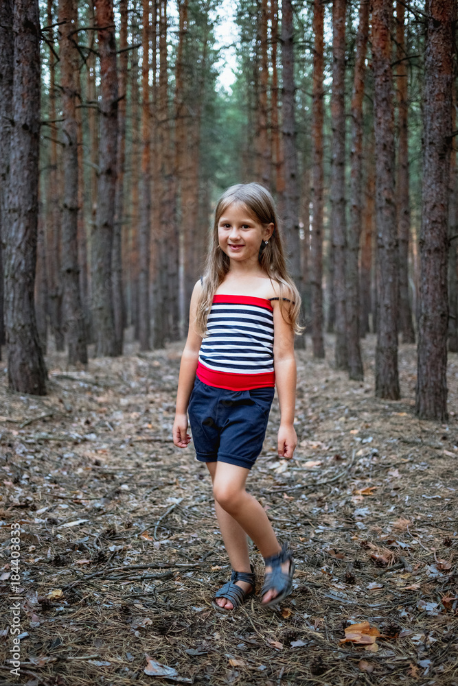Beautiful little girl in the pine forest in summer. Beautiful little girl in the pine forest in summer.