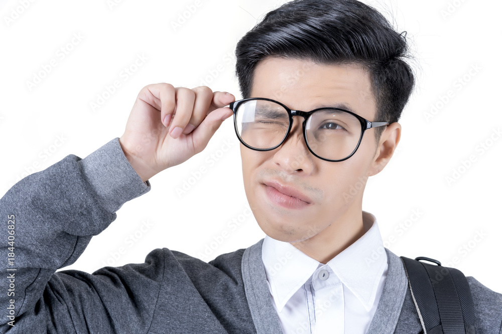 Close up young Asian male student in white shirt and grey jacket , hand touching eyeglasses and winking  isolated on white background