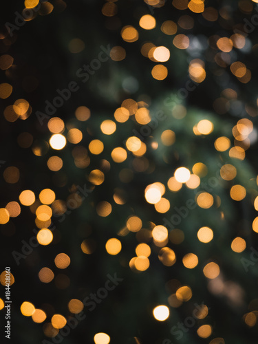 Blurry, golden Christmas fairy lights on outdoor christmas tree at the castle of Nuremberg in the snow during winter creating a beautiful bokeh effekt