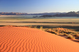 Sanddüne der Namibwüster im Vordergrund, grünliche Ebene im Mittelgrund und Tiras-Berge im Hintergrund.Where: Farm GUnsbewys bei Aus, D707, Namibia.