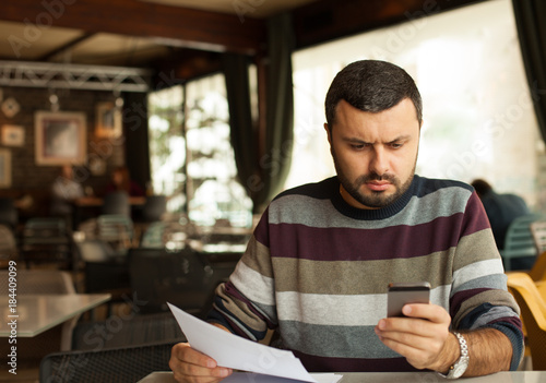Stressed man looking at phone
