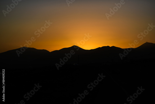 Sunset sun on Lanzarote, landscape of Canary Islands, sunset over volcanoes.