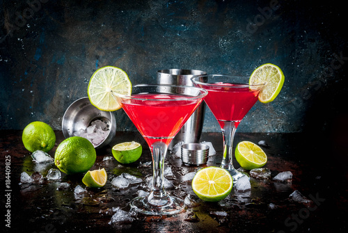 Red cosmopolitan cocktail with lime in martini glass, on dark rusty background copy space photo