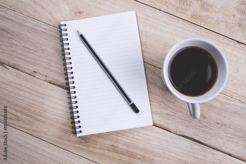 Top view Note book with pencil and a cup of coffee on wood table for Business Top view Note book with pencil and a cup of coffee on wood table for Business