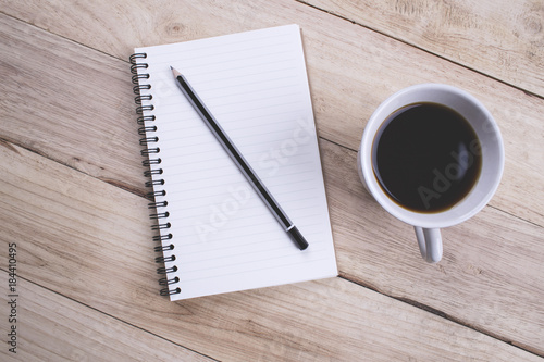 Top view Note book with pencil and a cup of coffee on wood table for Business