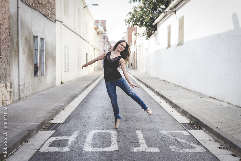 Classical ballerina dancing on the street dressed in casual clothes Classical ballerina dancing on the street dressed in casual clothes