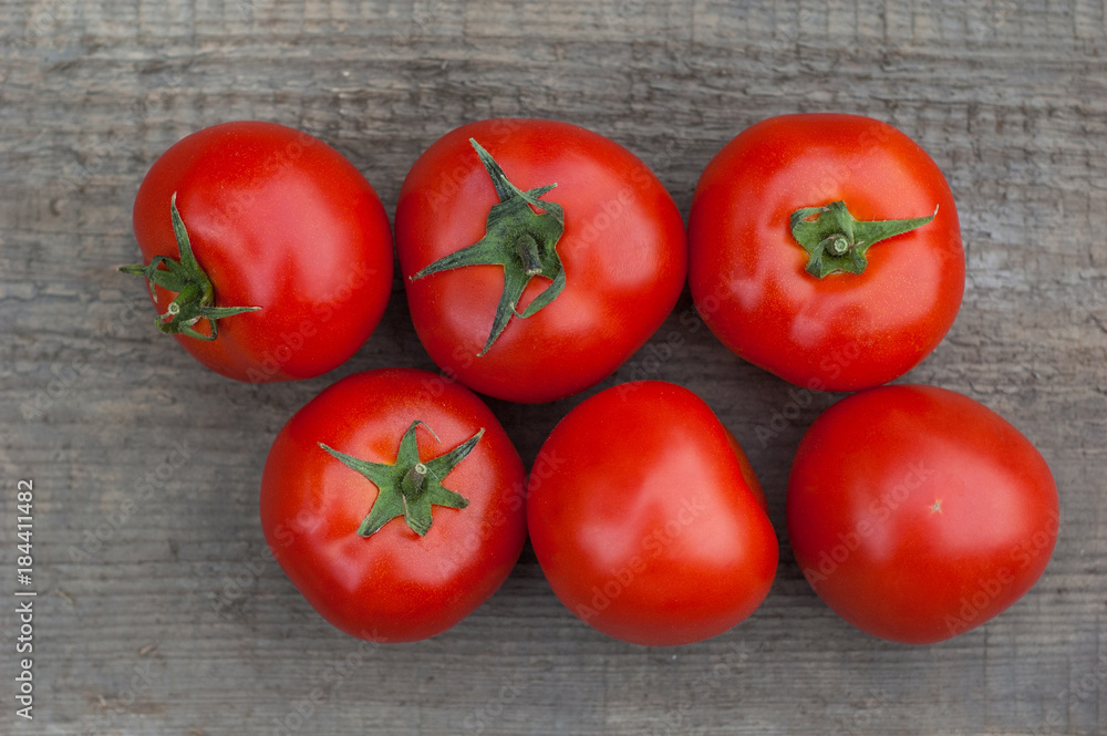 Several juicy red tomatoes on a wooden background. Several juicy red tomatoes on a wooden background.