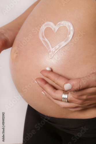 Wallpaper Mural Pregnant woman applying moisturizer on belly, preventing pregnancy stretch marks Torontodigital.ca