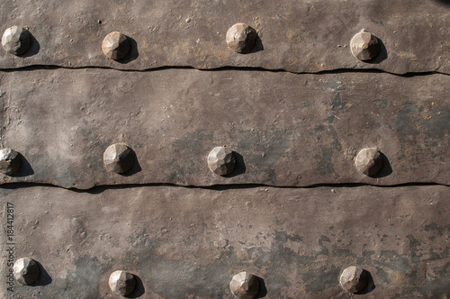 Detail of old medieval door with metal cladding surface and iron rivets  closeup as background Photos | Adobe Stock