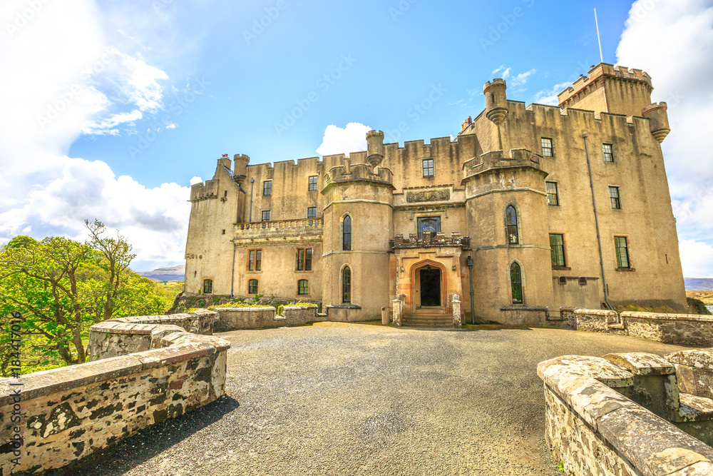 Front entrance of Dunvegan Castle in Dunvegan city of Isle of Skye, Scotland, United Kingdom on a sunny day in blue sky. Highlands of of Scotland in Loch of Dunvegan. Seat of the MacLeod Clan.