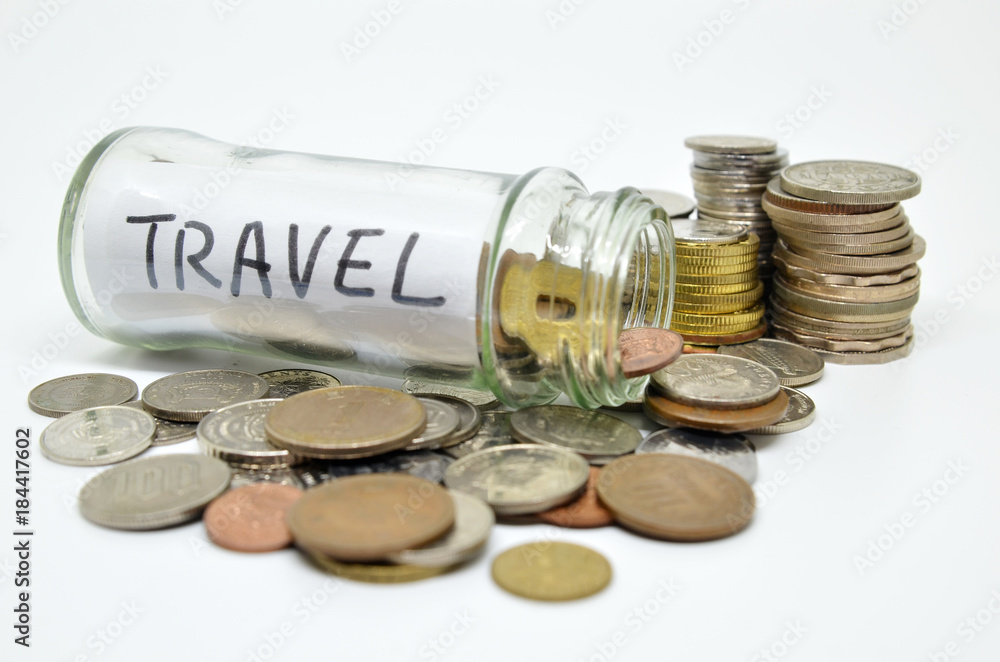 Travel lable in a glass jar with coins spilling out Travel lable in a glass jar with coins spilling out