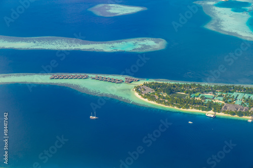 Maldives island aerial landscape view. Beautiful blue sea and luxury water villas. Seaplane aerial view of Maldives atoll and coral reef