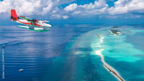 Fototapeta Naklejka Na Ścianę i Meble -  Maldives island aerial landscape view.  Beautiful blue sea and luxury water villas. Seaplane aerial view of Maldives atoll and coral reef